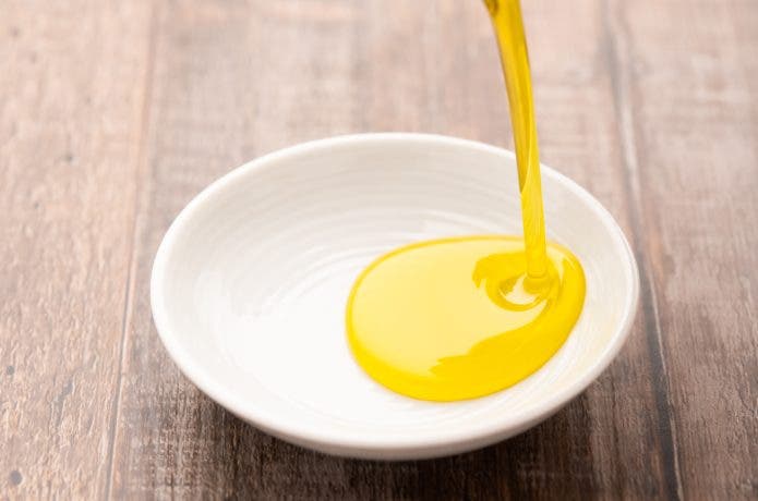 オリーブオイルを白い小皿に注ぐ