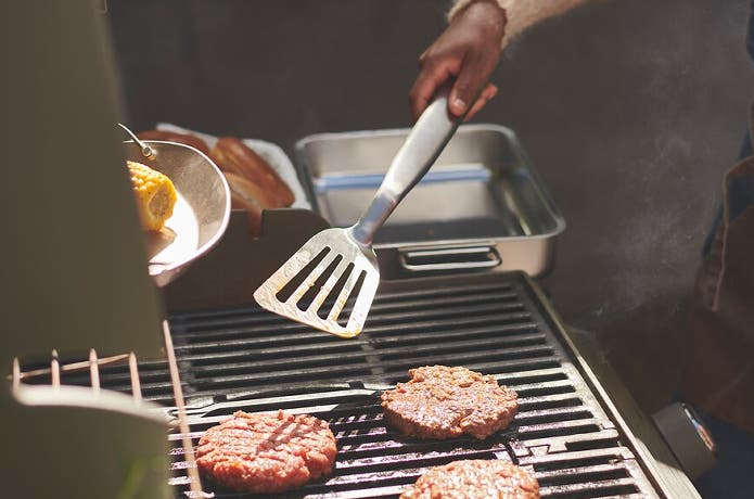 ビーターでグリルの上の肉を返す