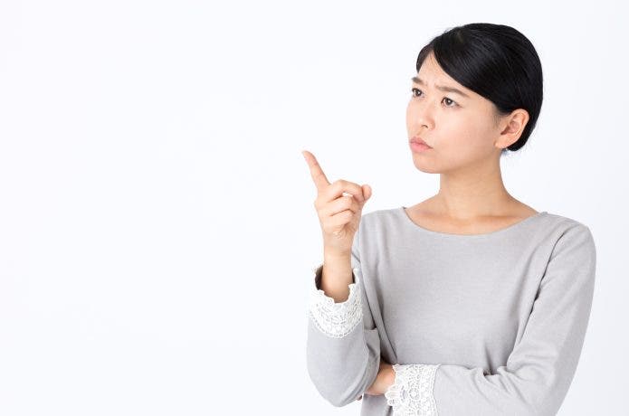 人差し指を立てて考える女性