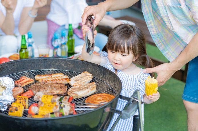 バーベキューコンロをのぞく子ども