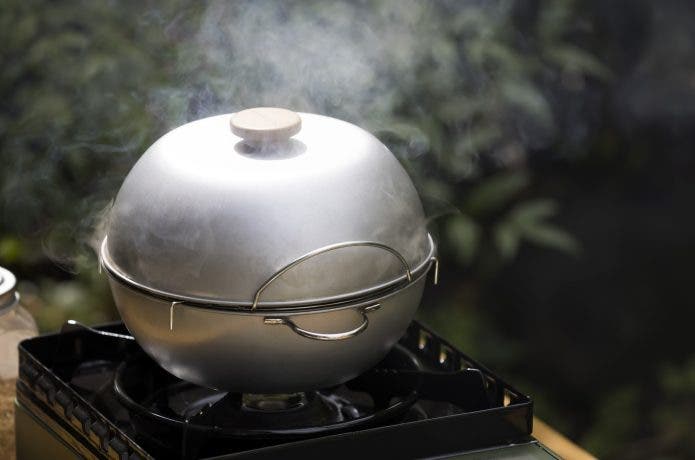 燻製器で食材を燻している。